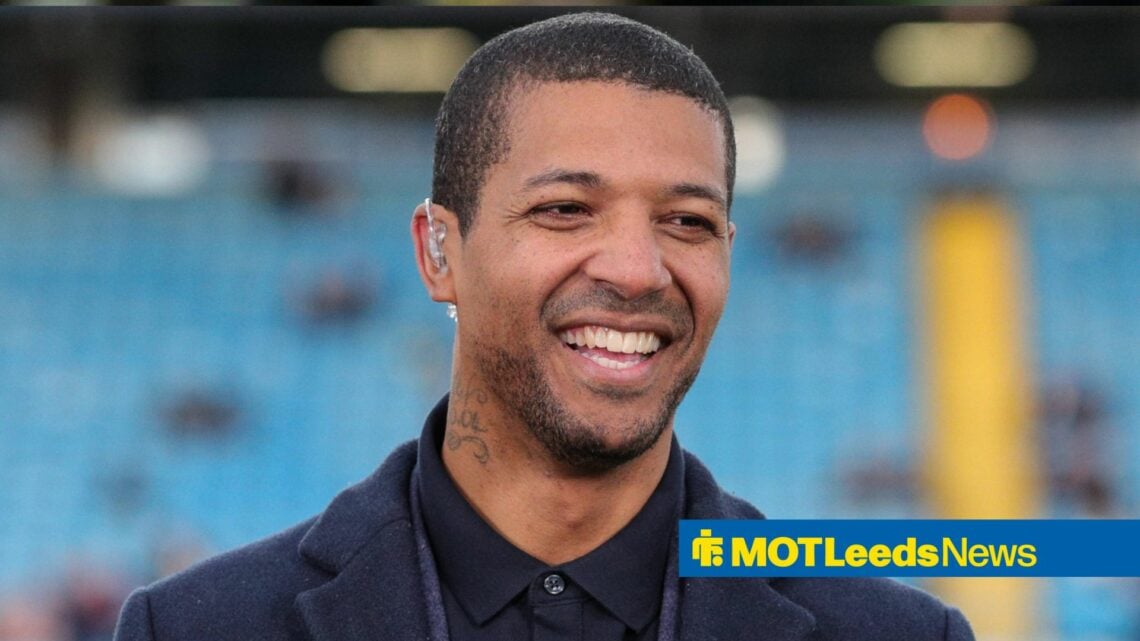 Jermaine Beckford smiling wearing earpiece at football stadium
