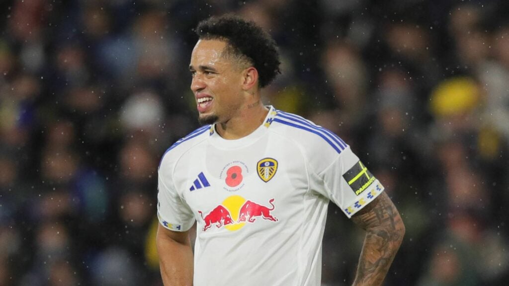Leeds United star Noah Okafor stands looking concerned during a game.