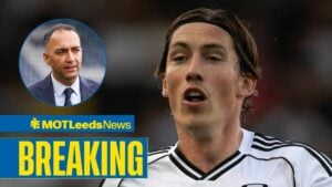 Leeds United owner Paraag Marathe in a blue suit at Elland Road while looking at Fulham winger Harry Wilson.