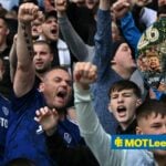 Leeds United fans looking angry towards a circle inset of Crystal Palace lifting the Conference League trophy
